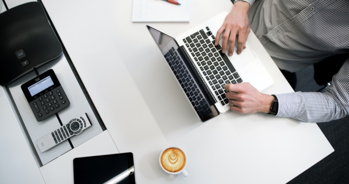 person using laptop on white wooden table