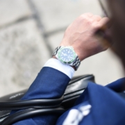 person looking at silver-colored analog watch