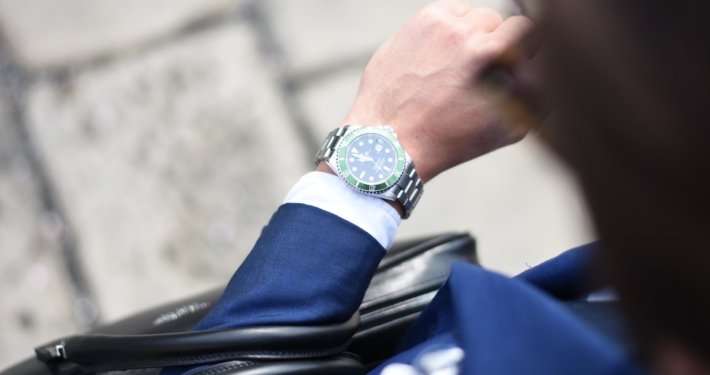 person looking at silver-colored analog watch